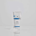 ROUND LAB Birch Juice Moisturizing Cleanser 150 ml tube covered with foam on a reflective surface — manufacturer photograph